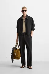 Pantalón negro de corte recto con cintura elástica, bolsillos laterales y un bolsillo trasero de ojal.
