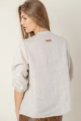 Camisa de jean celeste con cuello mao, abotonada al frente y mangas 3/4 con puños elásticos.