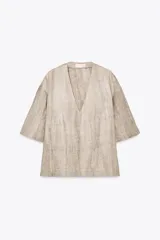 Top de lino color beige con estampado tie dye, escote en V y mangas 3/4.