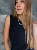 Vestido largo negro de un solo hombro, confeccionado en tela tableada con sutiles brillos.