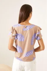 Remera color camel con estampado abstracto en forma de hojas color lila, mangas cortas con volados.