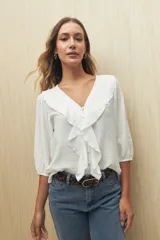 Blusa negra con mangas 3/4 y escote en V con volados.