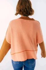 Sweater beige y azul con cuello en V y ribete bordeaux.