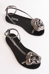 Sandalias Aura plateadas con aplique de flor en el empeine y tira fina al tobillo con hebilla.