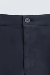 Pantalón chino color beige, corte skinny fit, confeccionado en tejido con mezcla de algodón y elasticidad. Cuenta con bolsillos frontales y traseros. Cierre frontal con cremallera y botón.