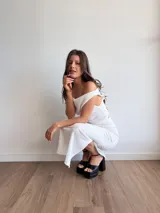 Conjunto blanco de dos piezas de tela bambula elastizada, compuesto por un top con escote recto y una falda midi con cintura elastizada.