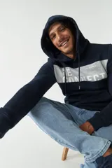 Canguro azul marino con capucha, corte oversized, bolsillo tipo canguro y estampado con la palabra "RECONNECT" en gris.
