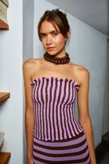 Crop top strapless con elástico en la parte superior e inferior, con franjas verticales color lila y marrón.