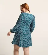 Vestido corto de crepé color verde azulado con estampado de mini corazones blancos, escote en pico, mangas largas con puños elásticos y cierre en la espalda.