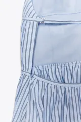 Top de popelina con rayas verticales celestes y blancas, cuello halter ajustable, detalle de frunces, espalda descubierta con tira ajustable y cierre lateral con cremallera oculta.