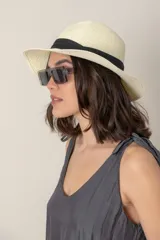 Sombrero de paja color beige con ala ancha y cinta negra decorativa.