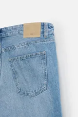 Pantalón de jean celeste de corte slim fit y tapered, con cinco bolsillos, efecto lavado y cierre frontal con cremallera y botón.