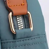 Bandolera negra de tela con correa larga regulable, cierre superior y bolsillo frontal con etiqueta marrón con la inscripción "Colorful Fox".