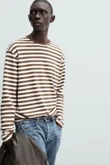 Remera de manga larga a rayas horizontales marrones y blancas, de corte recto y cuello redondo.