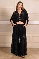 Pantalón palazzo negro de encaje con forro tipo short, pinzas, bolsillos y elástico en la cintura trasera.