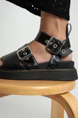 Sandalia de cuero con hebillas ajustables y plantilla acolchada, diseñada para ofrecer comodidad y un toque moderno.
