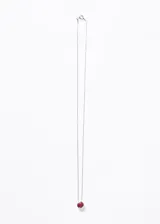 Collar con cadena de plata 925 y dije redondo con una piedra de rubí engarzada en un marco de plata.