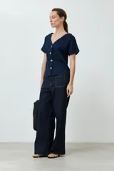 Remera azul marino de manga corta con cuello en V y cierre frontal con botones dorados.