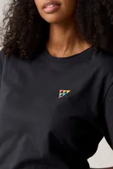 Remera negra de algodón con cuello redondo y estampado pequeño de triángulos de colores en el pecho.