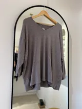 Sweater color visón de corte recto, con cuello en pico y punto elástico en los puños.
