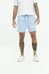 Short de baño celeste con rayas verticales blancas, cintura elástica con cordón ajustable, dos bolsillos laterales y uno trasero.