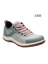 Zapatillas urbanas Hush Puppies modelo Rising Low, color gris con detalles en gris oscuro y rosa. Capellada textil impermeable, cordones rosas y suela de goma marrón.