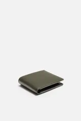 Billetera tipo cartera de corte liso color verde militar. Cuenta con un compartimento para billetes, tres compartimentos para tarjetas y un monedero con cierre mediante clip.