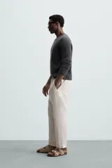Pantalón negro de lino, corte recto y relaxed fit, con cintura elástica ajustable con cordón, bolsillos laterales y traseros.