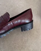 Mocasines negros con suela track y detalle de antifaz con textura croco.