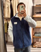 Campera de peluche azul con mangas blancas, cierre frontal y cuello alto.