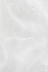 Top blanco de encaje con breteles finos y escote recto con volado festoneado.