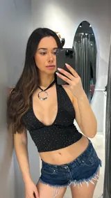 Top negro con escote halter y espalda descubierta, con pequeños apliques brillantes.