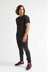 Jean skinny de hombre color negro, ajustado desde la cadera hasta los tobillos, con roturas en las rodillas y logo bordado en el bolsillo trasero.