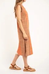 Vestido midi sin mangas, con rayas verticales en tonos naranja, beige y marrón. Confeccionado en tejido de punto suave al tacto.