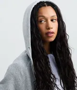 Saco negro de algodón con felpa, con capucha ajustable mediante cordón, mangas largas, cierre delantero de cremallera y bolsillos funcionales.