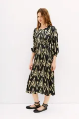 Vestido largo midi con escote redondo, confeccionado en viscosa negra estampada, con mangas 3/4 y lazo regulable en la cintura.