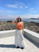 Top tejido al crochet color naranja, con tirantes finos y cierre frontal con lazos.