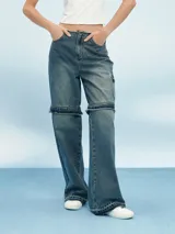 Pantalón de jean azul de corte ancho con aberturas a la altura de las rodillas.