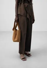 Pantalón marrón de lino para mujer, con cierre de botón, bolsillos laterales y raya de plancha en delantero y espalda.
