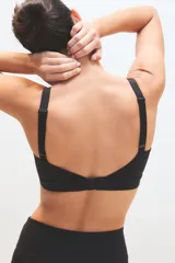 Top deportivo negro con breteles anchos y detalle de línea blanca en el escote.