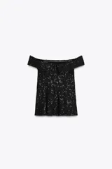 Top chaleco negro con escote recto y hombros descubiertos, con lentejuelas a tono y aberturas laterales.