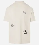 Remera color crema de corte relaxed con cuello redondo y mangas cortas. Presenta un bordado en el frente con motivos de cocoteros y sol.