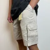 Bermuda cargo gris de gabardina, con bolsillos laterales y traseros.