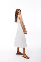 Vestido midi blanco de algodón con escote en V, abotonado al frente y cuello camisero. Cuenta con cinturón regulable con hebilla tipo carey.