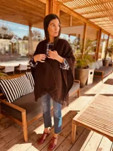 Ruana de lana merino color chocolate con flecos.