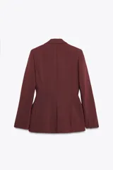 Blazer marrón de corte entallado, con cuello solapa, manga larga, bolsillos delanteros con solapa y cierre frontal con un botón.