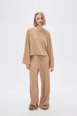 Top color beige de manga larga, holgado y cuello redondo.