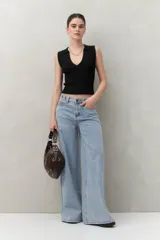 Pantalón de jean celeste de corte ultra wide, tiro medio y detalles metálicos en la cintura.