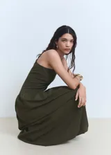 Vestido largo color verde oliva, de un solo hombro, con cierre lateral invisible y falda con volantes.