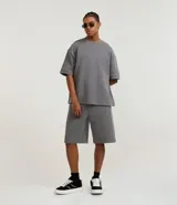 Remera color crema de corte amplio, con cuello redondo y mangas cortas con sisa desplazada. Confeccionada en algodón y poliéster.